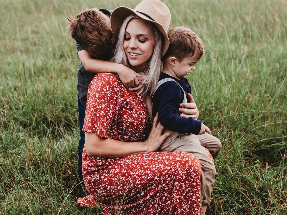  o que muda no estilo pessoal com a maternidade? Nesta imagem temos uma mulher com seus dois filho , na natureza. Neste artigo voce vai aprender a importância de se vertir de forma confortavel e arruma depois da maternidade