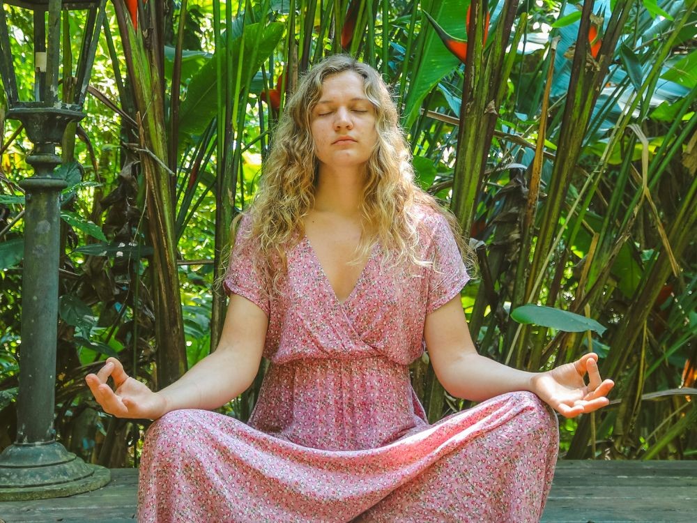 desenvolver autoconhecimento de forma prática e eficaz, Envolve tamebm a prática de meditação, nesta imagem temos uma mulher meditando em contanto com a natureza, a autoconhecimento está sim interligado com a espiritualidade. 